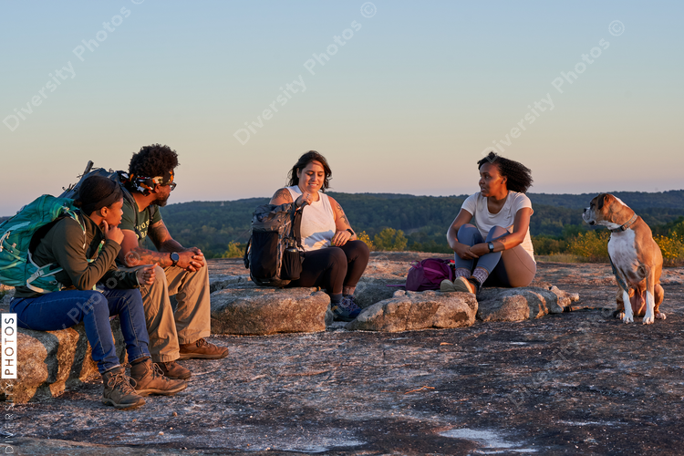 Friends enjoying weekend getaway on mountain top at sunset