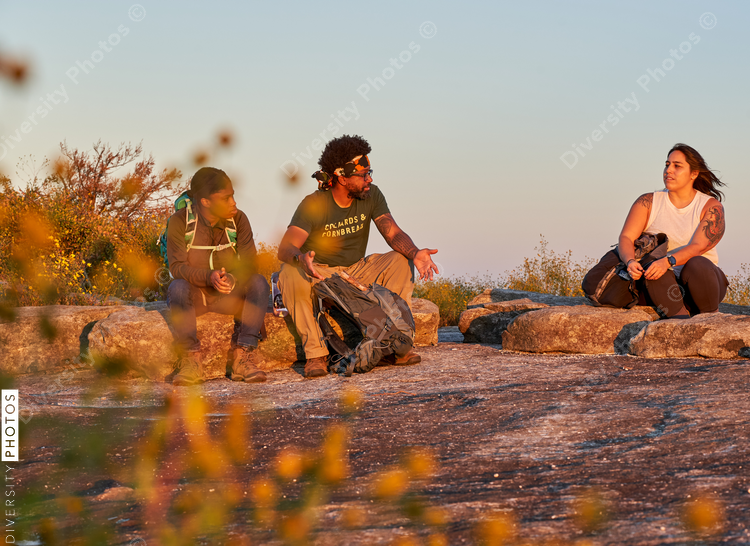 Friends enjoying weekend getaway on mountain top at sunset