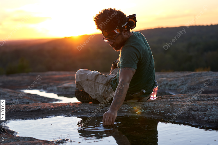 Man picking up rocks from water