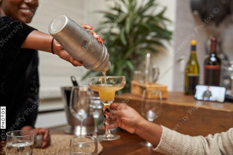 African American women creating DIY cocktails, friendship connections during self care retreat