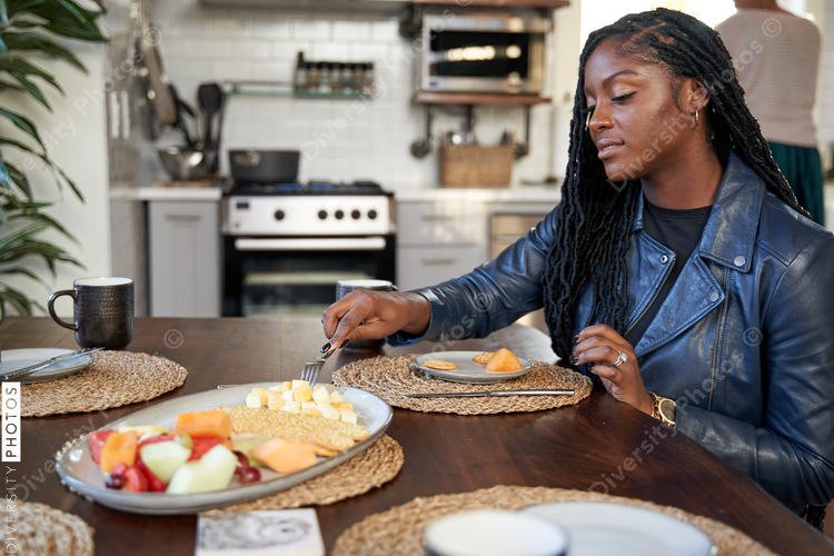 Black girlfriends talking and eating at table, friends togetherness