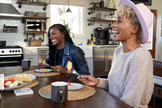 Black girlfriends talking and eating at table, friends togetherness