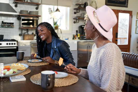 Black girlfriends talking and eating at table, friends togetherness