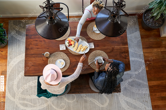 Black girlfriends talking and eating at table, friends togetherness