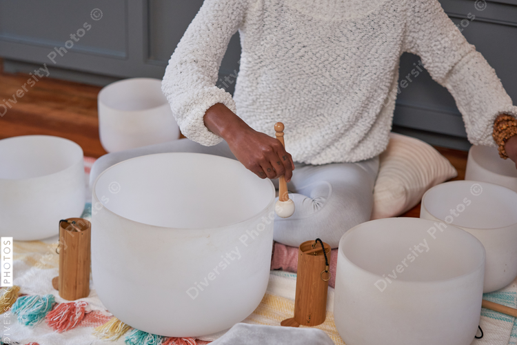 Black woman playing sound bath drums for mediation