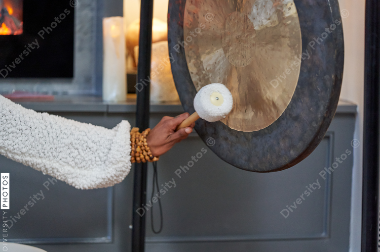 Black woman playing sound bath drums for mediation