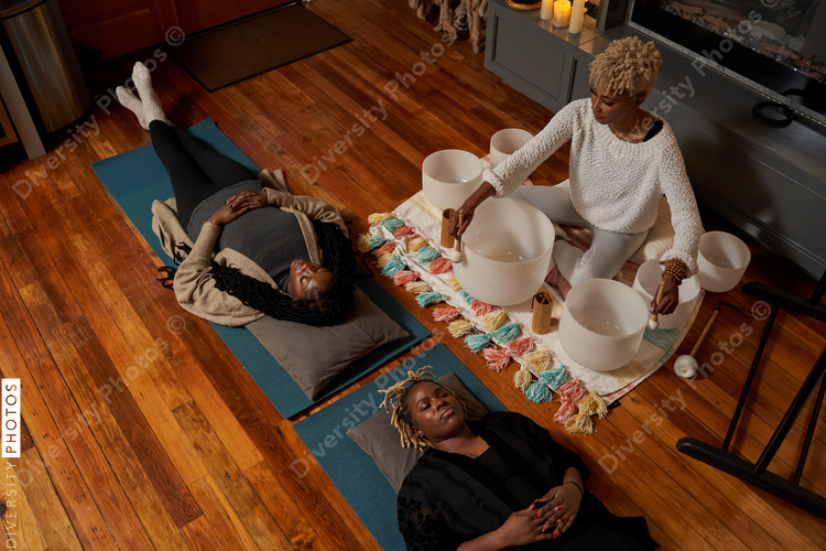 Black women having peaceful mediation laying down, self care retreat