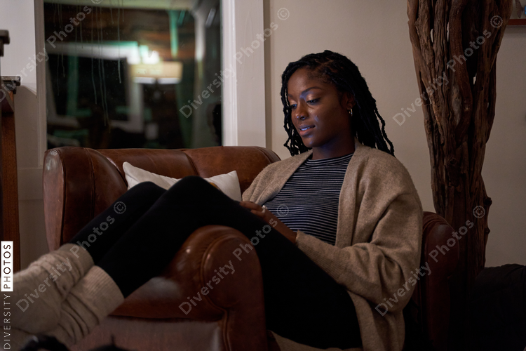 Black woman comfortable and cozy in chair of cellphone