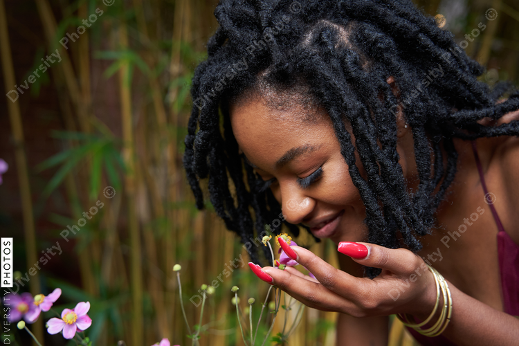 Black woman enjoying plants in garden