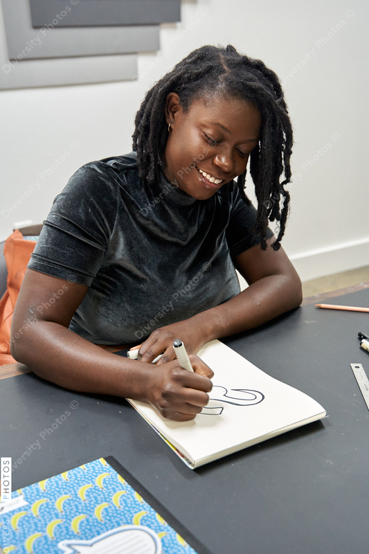 Black female artist creative drawing in studio