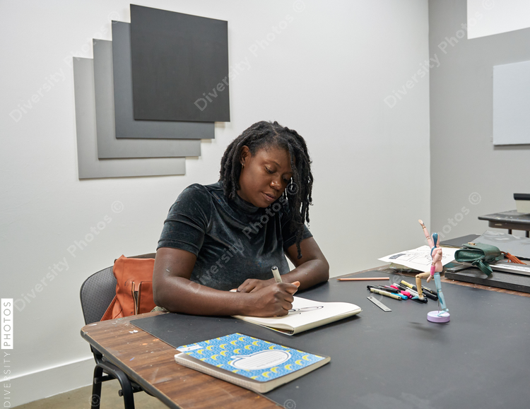 Black female artist creative drawing in studio