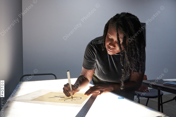 Black female artist creative drawing in studio