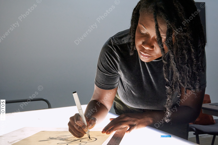 Black female artist creative drawing in studio