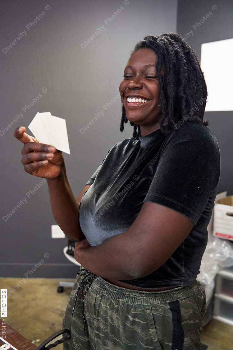 Black woman creative looking at card stock for art project