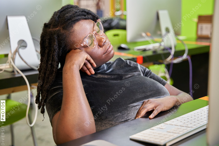 Black female college student tired and exhausted in computer lab