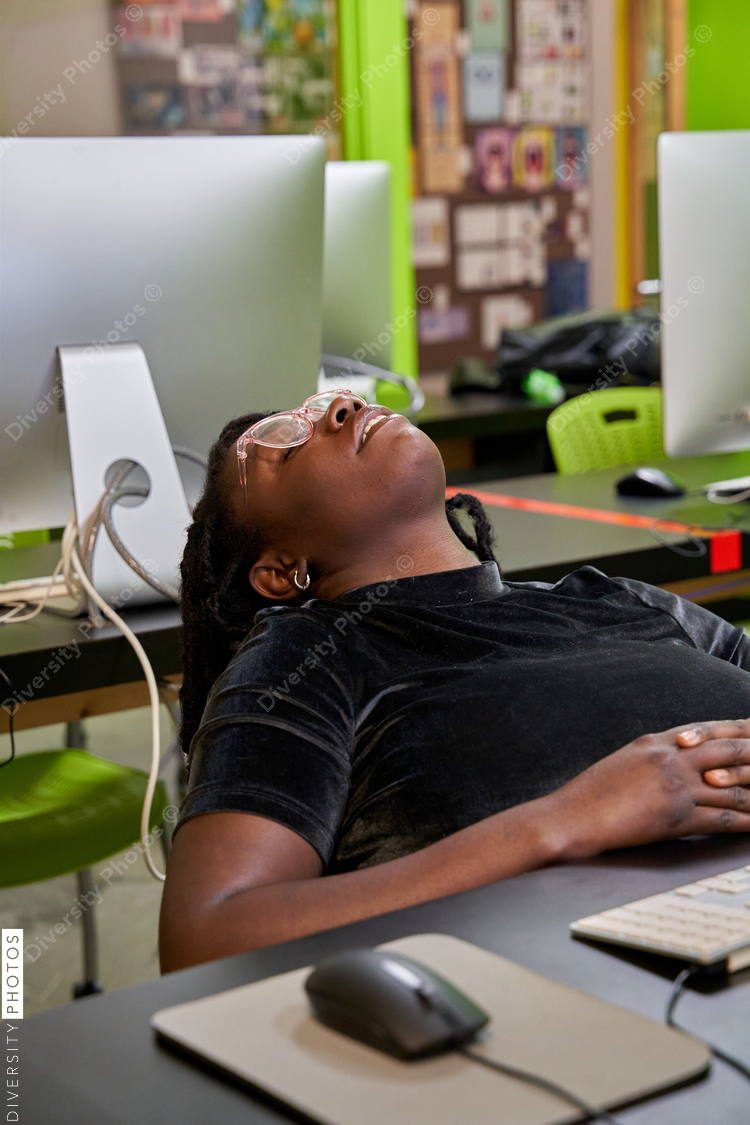 Black female college student tired and exhausted in computer lab