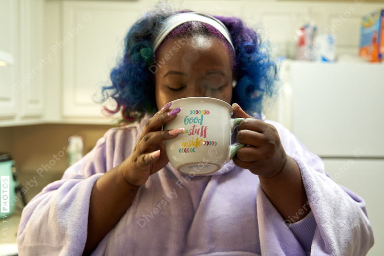 Black woman drinking hot cocoa at home, cozy and comfortable
