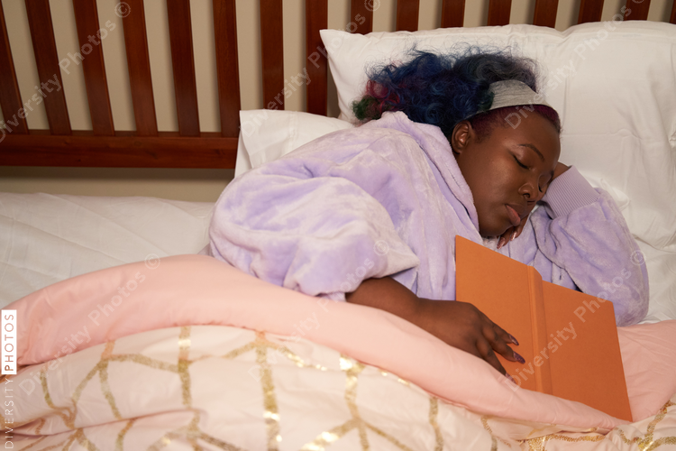 Black woman sleeping in bed, colorful hair