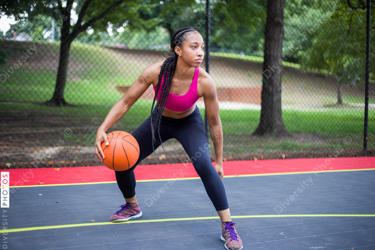Woman playing basketball and looking aside