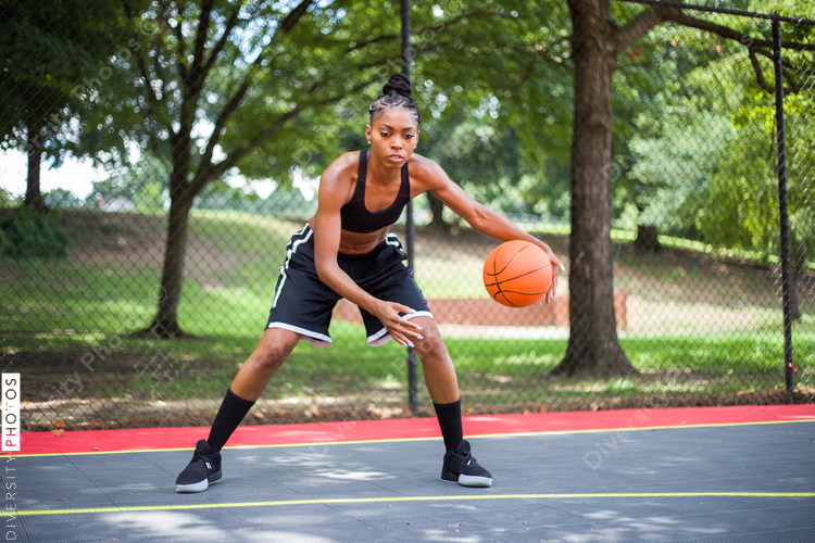 Woman playing basketball with greenery around