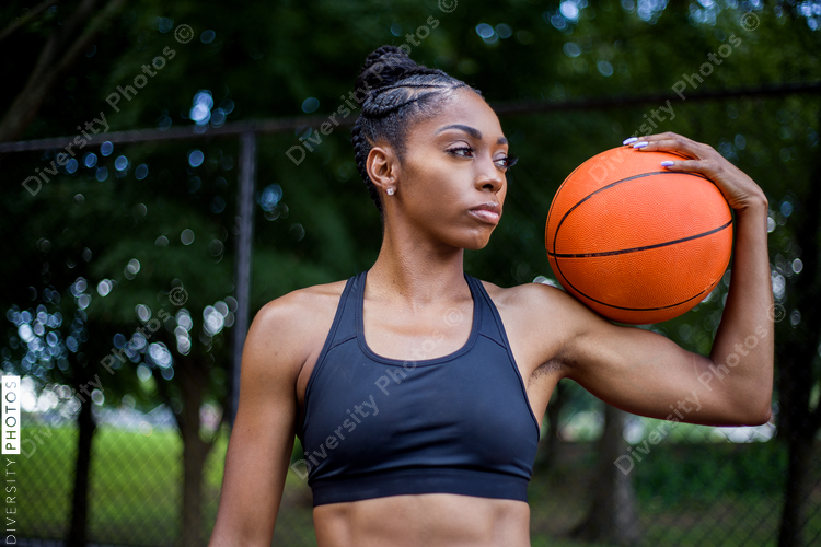 Woman holding basketball on her shoulder