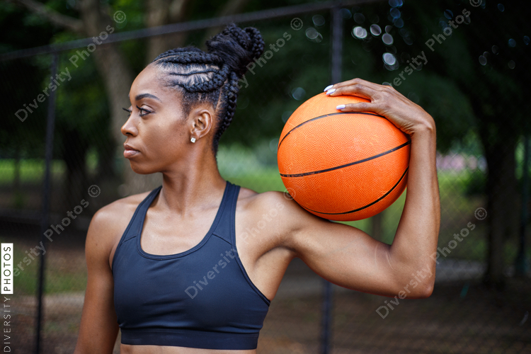 Close up view of woman with basketball on her shoulder