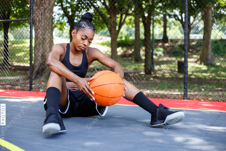 Woman sitting on basketball court