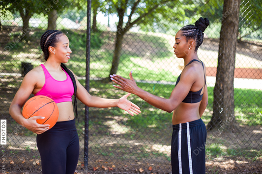 Women shaking hands while playing basketball