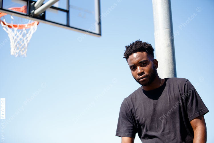 Black man in front of basketball goal