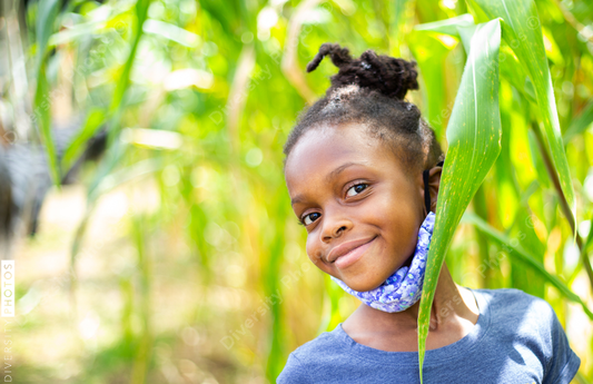 Young girl playing in cornfield outdoors