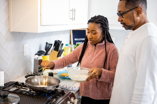 Black father shows daughter how to cook breakfast at home