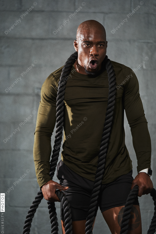 Black man training with battle ropes in crossfit
