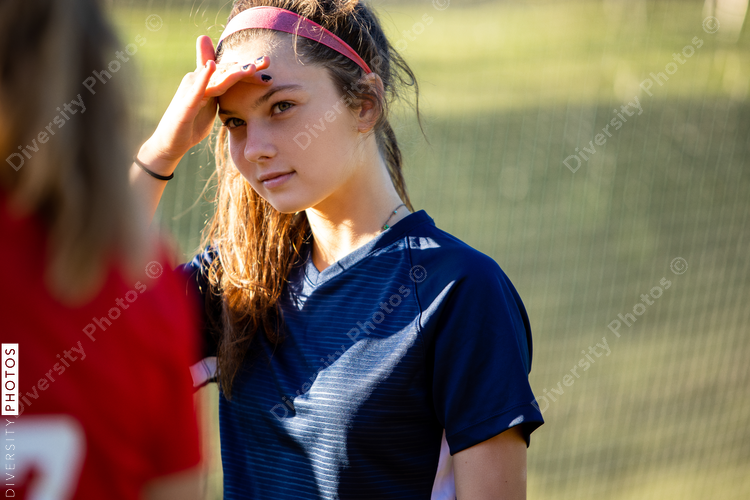Soccer player blocking sun and talks with opposing team