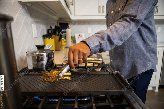African American man cooking dinner for family at home