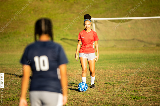 Young girls playing soccer scrimmage game