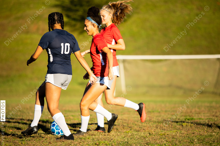 Young girls playing soccer scrimmage game
