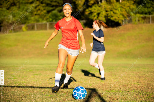 Young girls playing soccer scrimmage game
