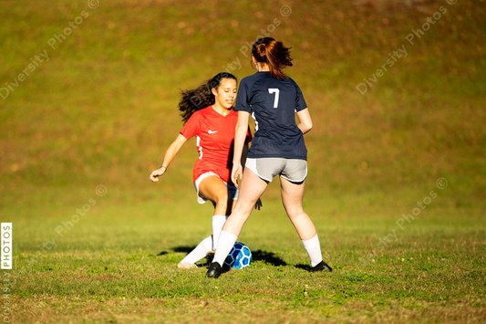 Young girls playing soccer scrimmage game