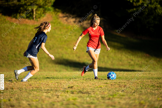 Young girls playing soccer scrimmage game