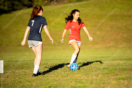 Young girls playing soccer scrimmage game