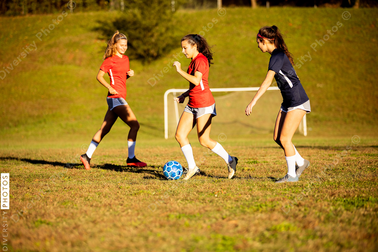 Female soccer player running by defender
