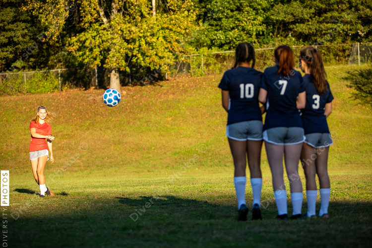 Girl kicking soccer ball in game