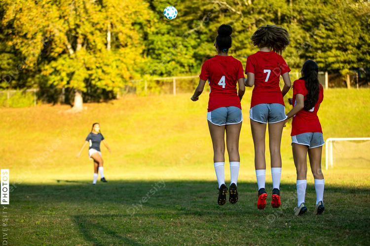 Girl kicking soccer ball in game