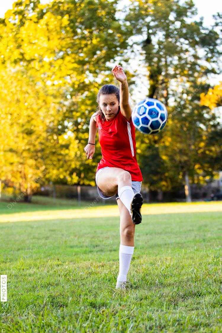 Latin female soccer player kicking ball