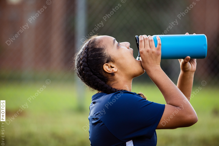 Female soccer player drinking water on field