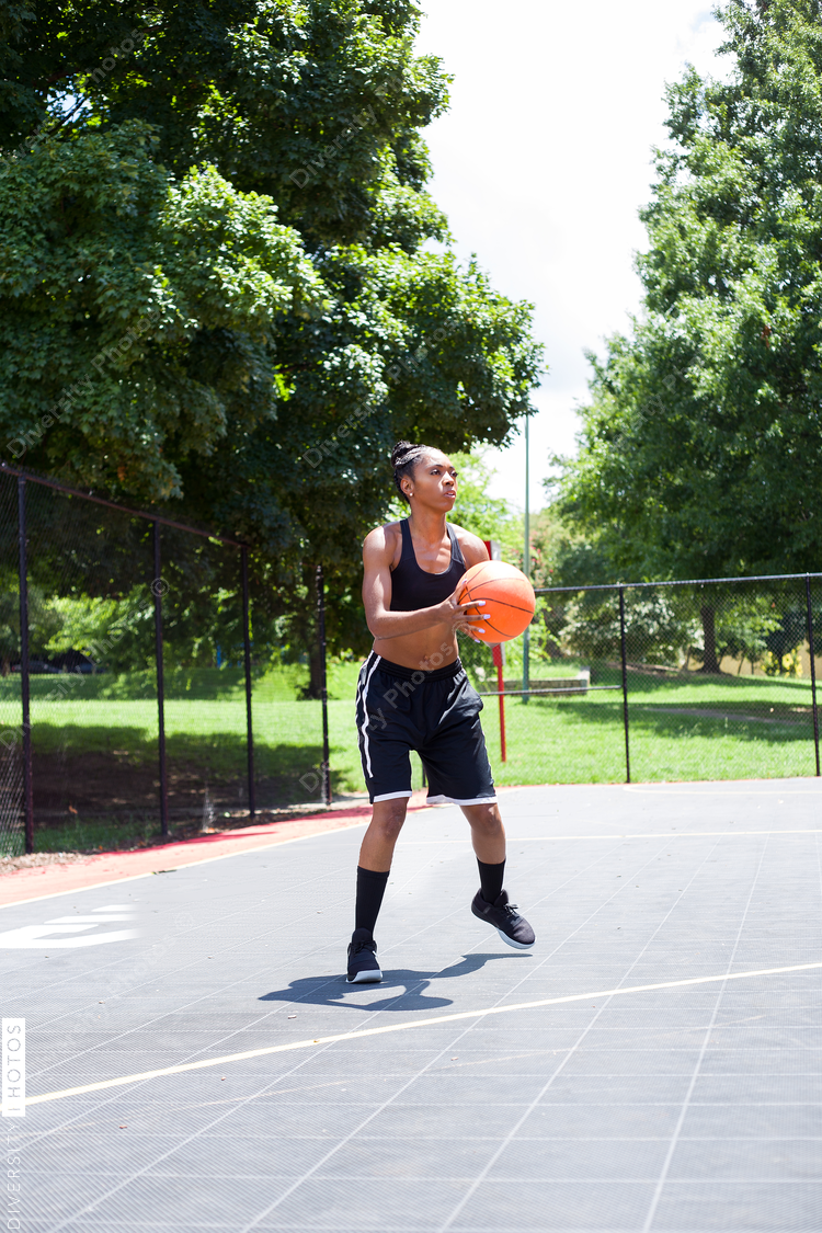 Woman in black playing basketball