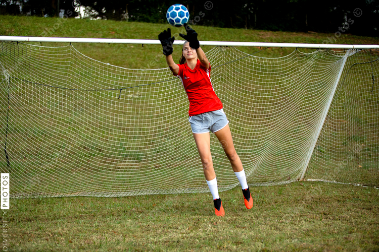 Female goalie blocks soccer ball