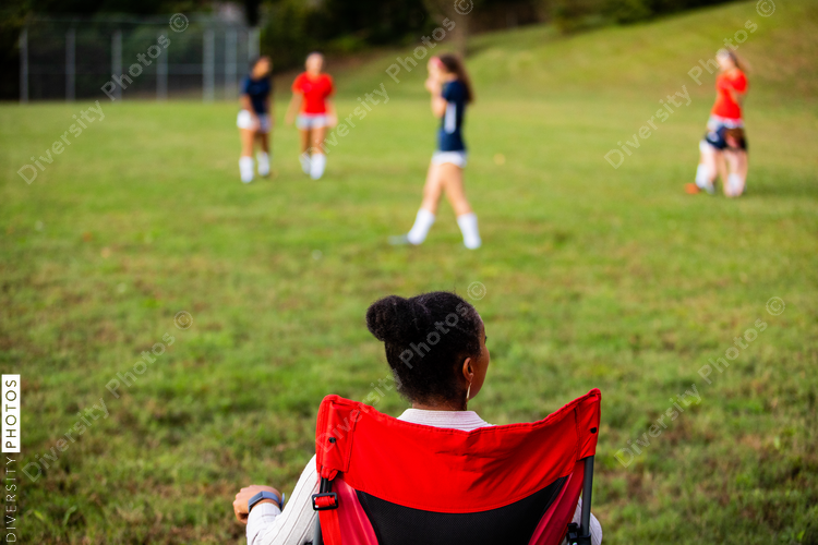 Supportive mom watches daughters play soccer