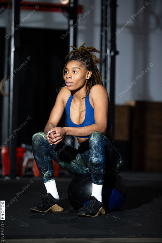 African American woman resting during workout at gym, sitting, health and wellness