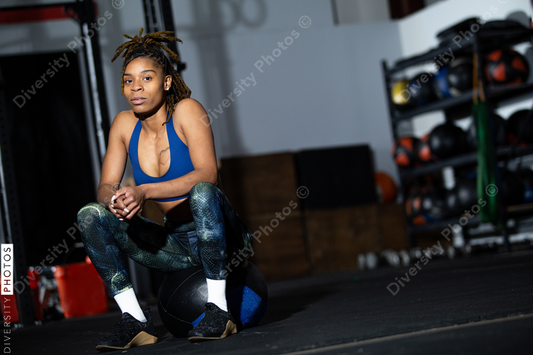 African American woman resting during workout at gym, sitting, health and wellness